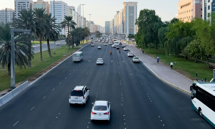 A highway with cars on it and buildings in the background